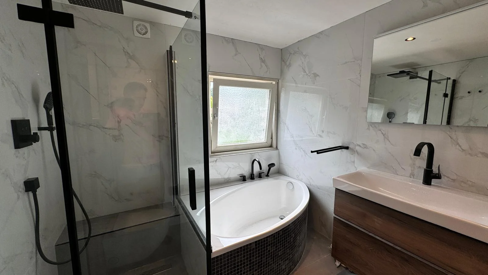 Bathroom in Bussum with corner bath, walk-in shower and marble-look tiles