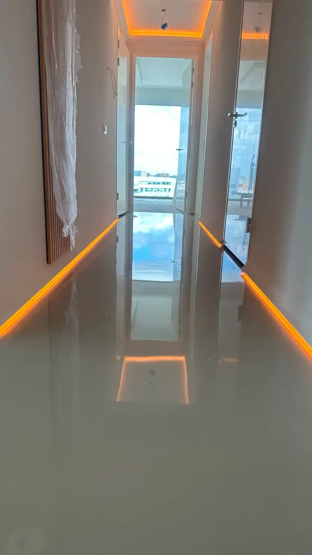 Gloss poured floor in a hallway with LED skirting lights